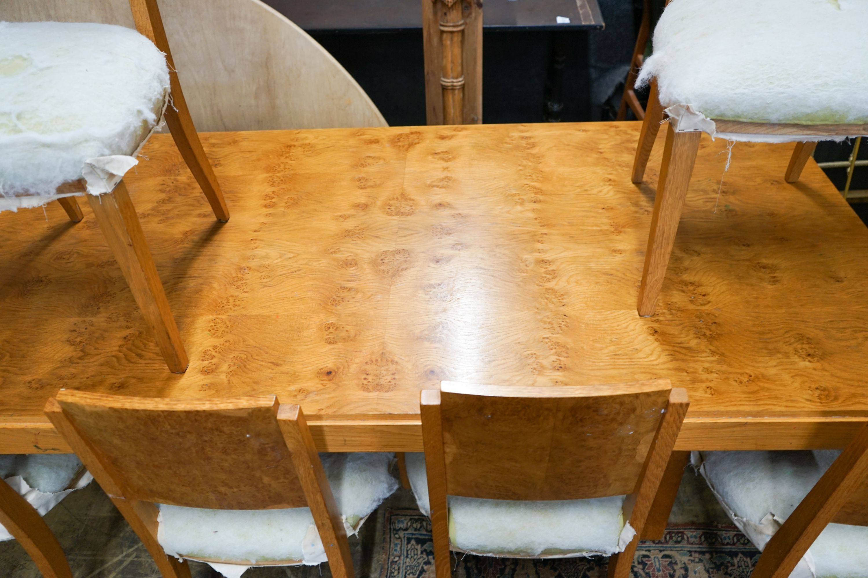 An Art Deco style bird's eye maple dining suite comprising table, six chairs and side cabinet, table length 200cm, width 104cm, height 72cm